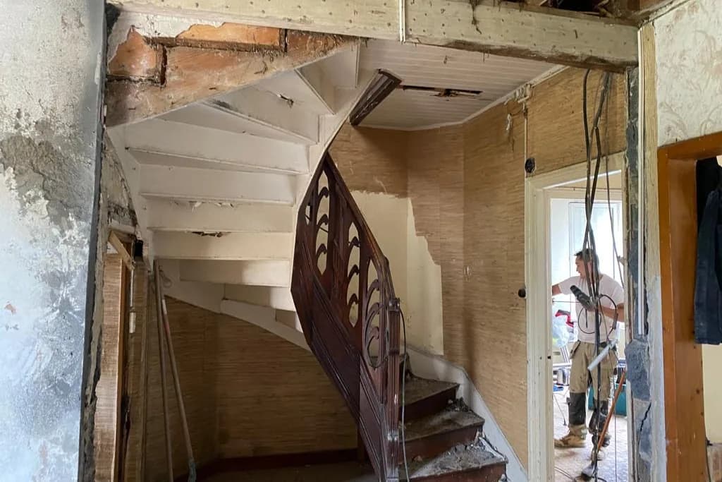 Escalier tournant en bois dans une pièce mise à nu